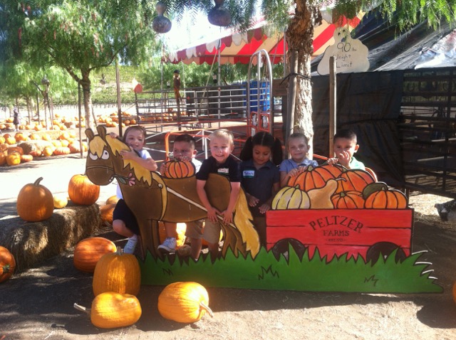 A photo of Hiatt posing with his classmates behind a pony prop